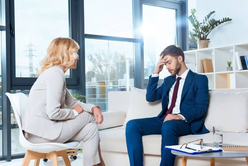 un paziente afflitto parla con la psicologa durante una consulenza psicologica